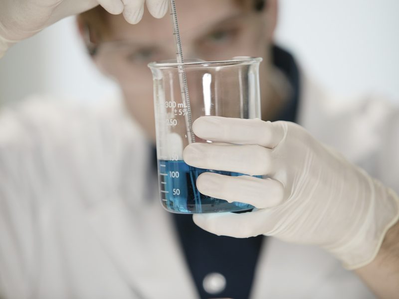 Water-treatment technician measuring a water sample in a lab beaker